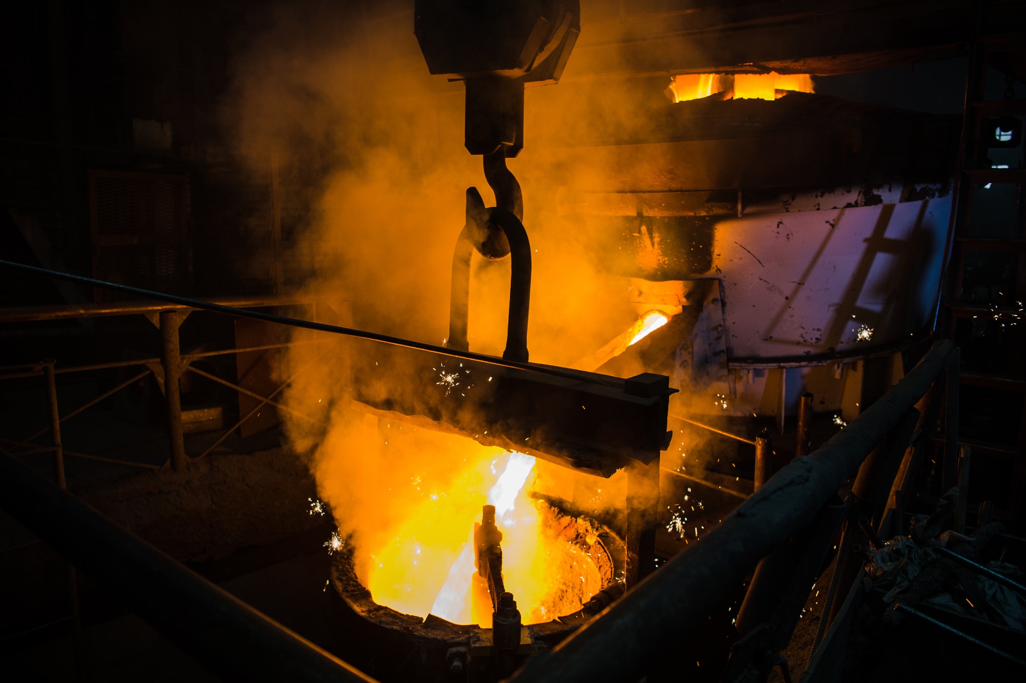 Molten steel pouring. Liquid hot metal of steel spills out of the ladle at steel factory Molten steel pouring. Liquid hot metal of steel spills out of the ladle at steel factory